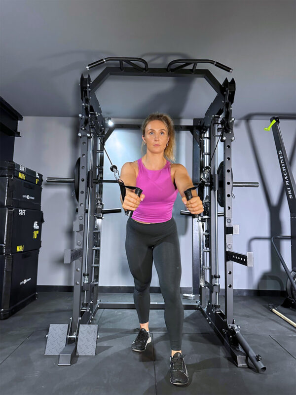 Woman doing cable rows on home gym squat rack