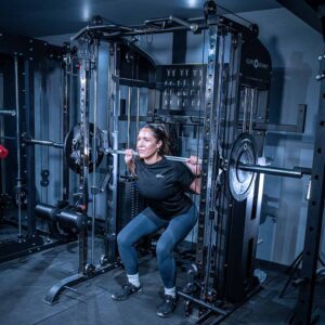 Woman using Multigym with Smith Bar, Weight Stack and Pull Up bar