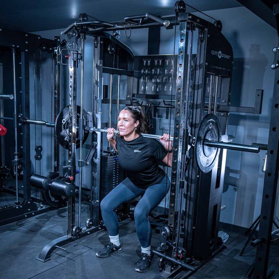 Woman using Multigym with Smith Bar, Weight Stack and Pull Up bar
